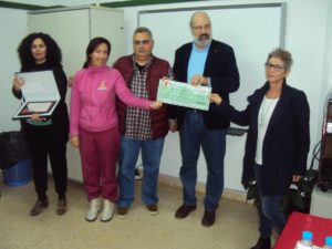 Momento de la entrega del cheque y placa con el dinero recaudado 