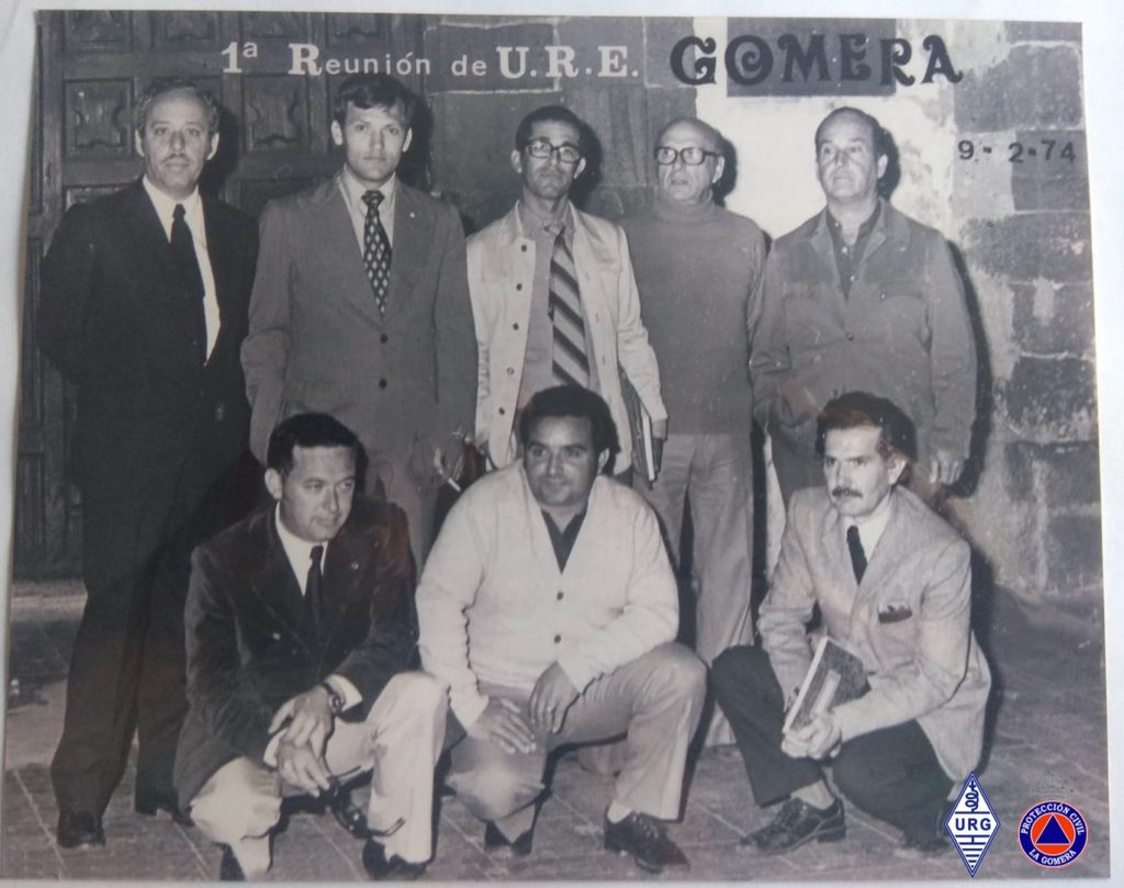 En la foto, atrás, de izquierda a derecha, Salvador Piñero EA8PA, Néstor Segredo (radioescucha), Sito Simancas EA8KT, José Fernández Galván (D. José el farmacéutico) EA8BT, Santiago Trujillo (radioescucha). Delante, de izquierda a derecha, Jaime Vega EA8PK, Vidal Tomé EA8KP y Asencio Ayala (radioescucha).