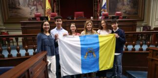 La presidenta del Parlamento entrega la bandera canaria que acompañará a los estudiantes seleccionados para la Ruta Quetzal 2026