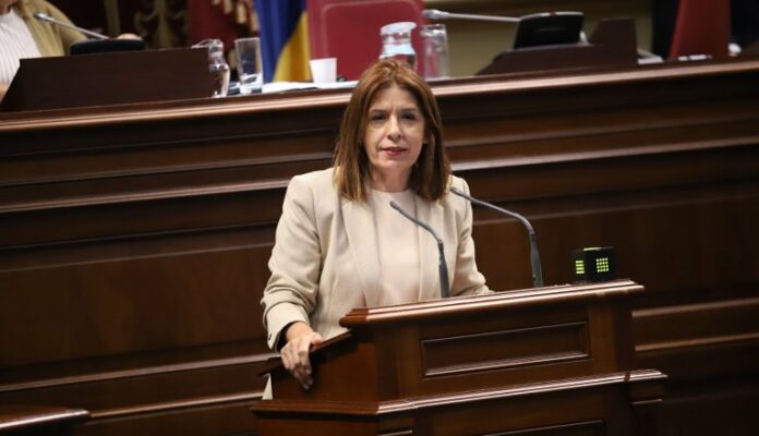 La diputada de Nueva Canarias-Bloque Canarista (NC-BC) Carmen Hernández denunció hoy el rechazo de la mayoría del Gobierno presidido por Fernando Clavijo de CC, PP, ASG y la AHI a su proposición no de ley para garantizar la excelencia, la continuidad pedagógica y la calidad educativa del alumnado de las escuelas oficiales de idiomas (EOI). Hernández denunció la negativa del Ejecutivo de las dos derechas canarias a dar estabilidad a los interinos que, en algunos casos, encadenan incluso durante siete años contratos de septiembre a junio y que se quedan sin cobrar el verano. La parlamentaria de NC-BC trasladó, esta semana al plenario, una iniciativa elaborada a partir de las reivindicaciones del profesorado interino de estos centros, que reclaman soluciones a la precariedad laboral, mayor estabilidad en el empleo y medidas que permitan asegurar la continuidad del personal docente en los centros. Hernández subrayó que la iniciativa recoge las demandas de un colectivo que considera fundamental para garantizar la calidad de la enseñanza de idiomas en las islas. Recordó la importancia estratégica de las escuelas oficiales de idiomas en una economía que depende del turismo. Uno de los principales problemas expuestos por Hernández es la cobertura de docentes, que se prolonga durante todo el curso mediante sustituciones. Advirtió de que esta situación provoca que los profesionales encadenen contratos temporales, finalicen su relación laboral en junio y se queden sin ingresos durante el verano, a pesar de que las necesidades docentes pueden repetirse año tras año. Puso como ejemplo el caso de profesionales que llevan hasta siete años consecutivos encadenando este tipo de contratos, lo que calificó de inaceptable. Según los datos expuestos por Hernández, durante el curso anterior el 63 por ciento de las vacantes adjudicadas fueron a jornada parcial, frente al 37 por ciento a jornada completa. Cuestionó que una persona que cubre una necesidad educativa durante todo el curso tenga que soportar condiciones laborales precarias por trabajar a tiempo parcial. La proposición no de ley reclamaba revisar la clasificación de las plazas para evitar que las necesidades se cubran con contratos que finalizan el 30 de junio, así como estudiar las fórmulas necesarias para recuperar determinadas retribuciones que el profesorado interino perdió tras la aplicación del segundo protocolo para la gestión del profesorado interino y sustituto, vigente entre 2011 y 2012, según expuso la diputada. NC-BC defiende que la temporalidad no debe traducirse en una penalización laboral y reclama condiciones dignas para un colectivo que desempeña una función esencial en el sistema educativo público. Advirtió, además, de que la falta de estabilidad favorece que los docentes cualificados abandonen las escuelas oficiales de idiomas, lo que dificulta la continuidad de los equipos educativos y repercute en la calidad de la enseñanza. Por ello, la iniciativa planteaba que los nombramientos se realizaran durante los primeros días de septiembre y que los procedimientos de contratación se adapten a las particularidades organizativas de estas enseñanzas. La diputada de NC-BC reprochó a los grupos que respaldan al Ejecutivo su rechazo a la propuesta y les pidió que justificaran su posición con argumentos políticos, en lugar de cuestionar a quienes trasladan al Parlamento las reivindicaciones de los colectivos afectados. Carmen Hernández rechazó que los problemas denunciados estén ya resueltos. La parlamentaria de NC-BC instó al consejero Poli Suárez y a los grupos del Gobierno a comprometerse públicamente a que las necesidades docentes se cubran con contratos adecuados y condiciones laborales dignas. 1